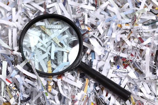 a magnifying glass in a pile of shredded paper