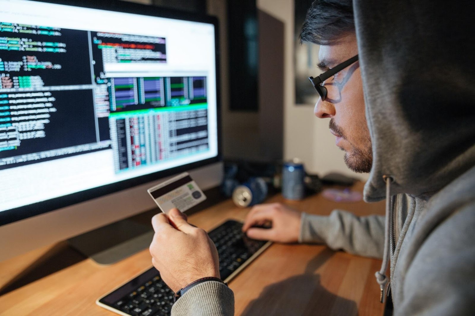 a man looking at a screen while holding a credit card