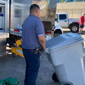 On-site worker pushing a secure shredding container