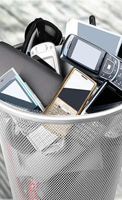 A waste bin filled with electronics and old cell phones